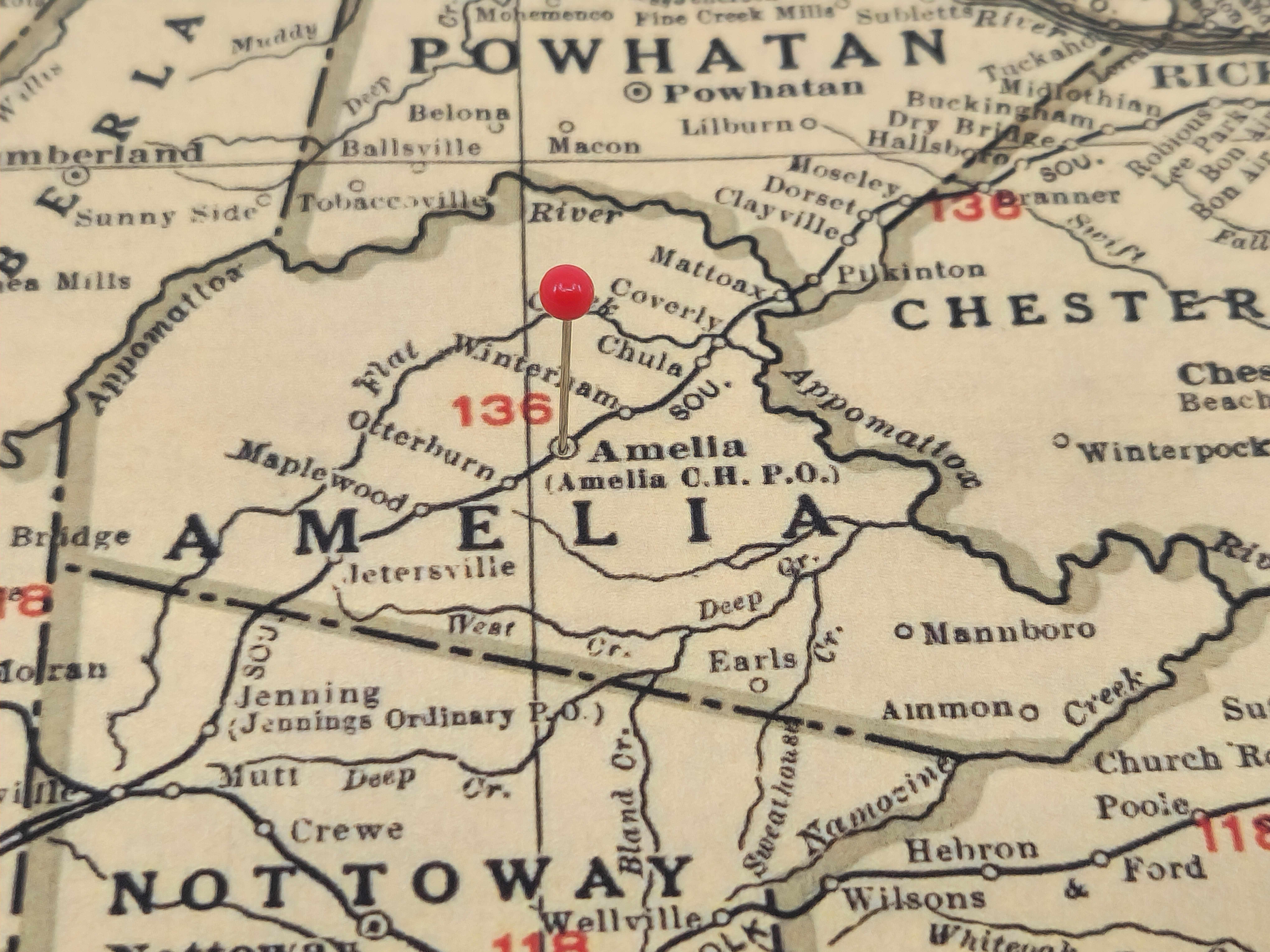 A vintage map with a red pin showing Amelia County.